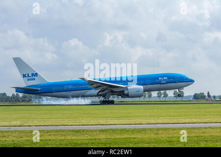 Schiphol Airport, the Netherlands - August 20, 2016: KLM boeing 777 commercial jet aircarft landing with smoke from the tires Stock Photo