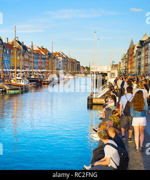 COPENHAGEN, DENMARK - JUNE 16, 2018: Tourists at Nyhavn district  - is one of the most famous landmark in Copenhagen
