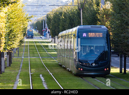Bordeaux, France - 27th September, 2018: Modern public tranport trams passing through tree lined streets in the city of Bordeaux.
