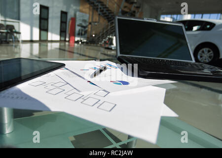 laptop and financial documents on a Desk in a spacious office Stock Photo