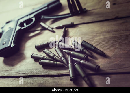 gun and ammunition on wooden table Stock Photo