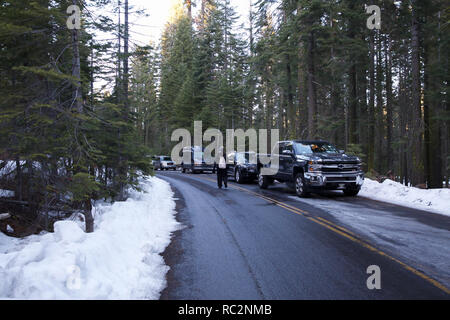 A lady walking along the road with Heavy Snow either side in Groveland, Yosemite, USA Stock Photo
