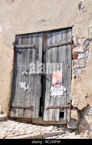Around Corsica - Doors used as a notice board, with interesting patterns and shadows. Stock Photo