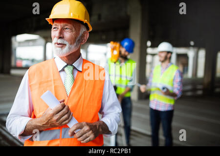 Engineer and construction site manager dealing with blueprints and plans Stock Photo