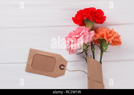 Bouquet of colorful carnation flowers. Top view. White wood background. Stock Photo