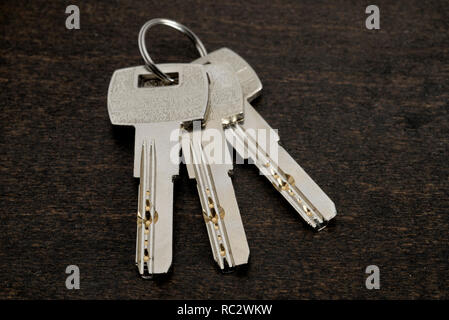 Key ring with keys over wooden background. Rent, buy home Stock Photo
