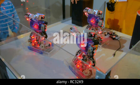 Humanoid robots with colourful illumination dancing at technology exhibition. Future and robotic concept Stock Photo