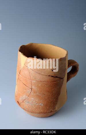 Bisque ceramic jar with a handle. Diameter mouth 10.9 cm Height 7, 7 cm. Medieval period from the archaeological site of the 'Calle Tercia' in Alcalá de Henares - ' Burgo de Santiuste Museum.' (Madrid). SPAIN. Stock Photo
