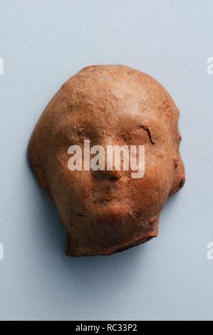 Child's head of terracotta figurine .Height 4 cm Width 3, 4 cm.(1 st - 3 rd CE ) - Roman period from ' House of Griffins '- Archaeological site of Complutum in Alcalá de Henares ( Madrid ). SPAIN. Stock Photo