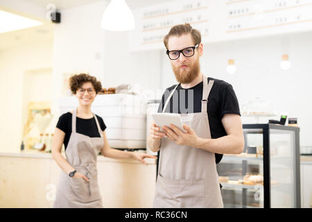 Content young waiter in coffee shop Stock Photo