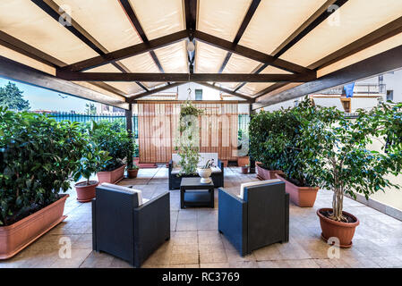 Exterior covered patio with furniture and plantes.  - Image Stock Photo
