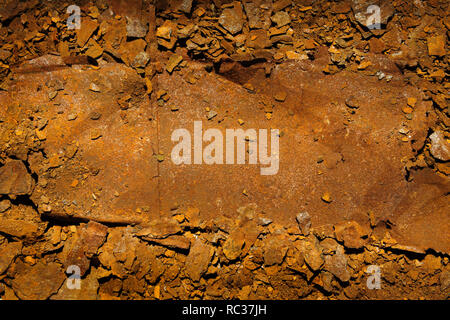 Flakes and sheets of dry rusted metal from corroded metal bucket. Stock Photo