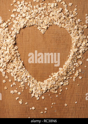 Heart shape of organic oat meal on a rustic wooden oak plank Stock Photo