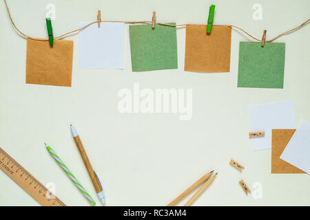 Kraft and white paper stickers with clothespins on a rope. Copy space Stock Photo