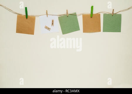 Kraft and white paper stickers with clothespins on a rope. Copy space Stock Photo