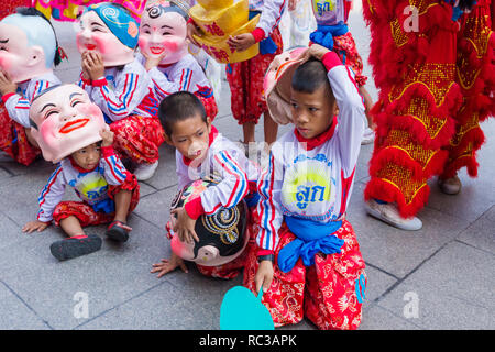 after a dance of the lions the participants take a little rest during Chinese New Year Celebrations in Chinatown, Bangkok Thailand Stock Photo