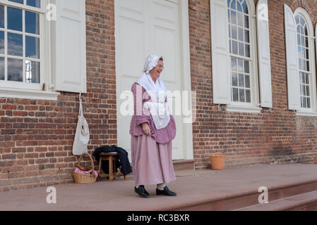 Williamsburg, VA, USA --  January 9, 2019. A woman dressed in period costume greets visitors to the coourthouse in colonial Williamsburg. Stock Photo