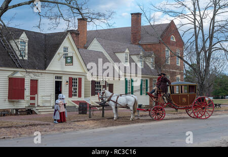 Williamsburg, VA, USA --  January 9, 2019. Photo of horses, carriage and drivers in period costume by a hitching post in Colonial Williamsburg. Stock Photo