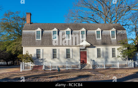 Williamsburg, VA, USA — Jan 10, 2019. A Dutch colonial house in Williamsburg with a  red door, surrounded by a white picket fence. Stock Photo