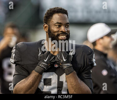 Oakland Raiders defensive end Justin Tuck (91), middle linebacker Miles  Burris (56) and safety Charles Woodson (24) surround Kansas City Chiefs  tight end Travis Kelce (87) as he picks up a first