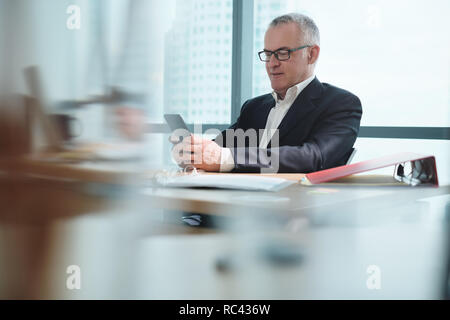 Business Man In Office Using Social Media During Working Hours Stock Photo