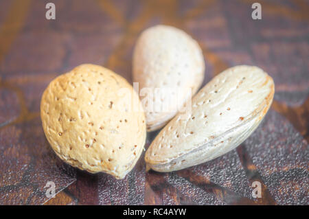 Macro shot of raw almonds kept on a wooden table. Details of almond shell Stock Photo