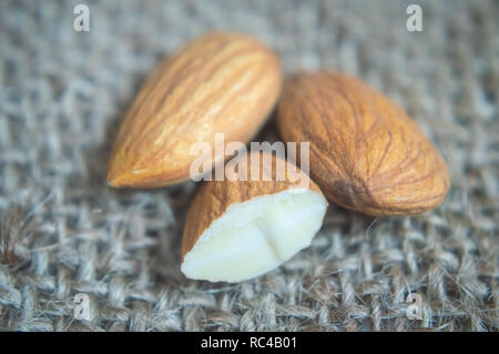 Close-up shot of almonds kept on a jute cloth. Details of almond Stock Photo