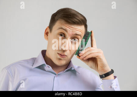 young man leaned against the head of the RAM Board isolated on a light background Stock Photo