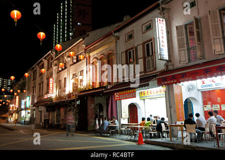 Old but renovated shophouses and few people sitting in restaurants on Smith Street in Singapore's Chinatown, at night. Stock Photo