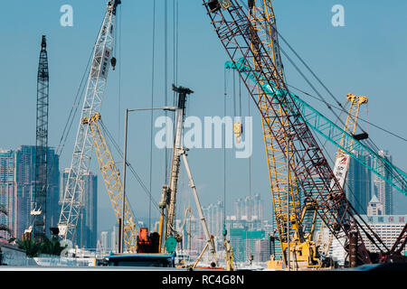Harbor cranes infront of city buildings in sunny day Stock Photo