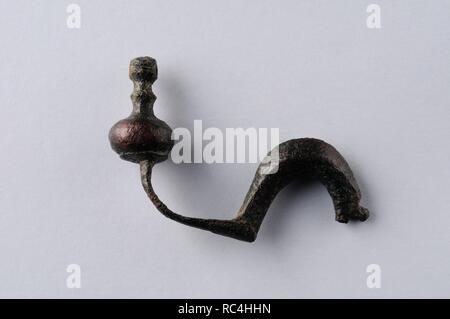 Bronze fibula , back foot type without needle . Length 45 mm Width 7 mm. ( 1 st - 3 rd CE ) - Roman period, from the ' La Dehesa '- Archaeological site of Complutum in Alcalá de Henares ( Madrid ). SPAIN. Stock Photo