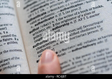 Close up of the word authoritarian on a page inside an English dictionary -  authoritarian concept Stock Photo