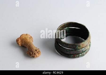 Ring of three soldiers copper rings associated with small phalanx bone . Ring 2,2 cm x 1, 1  Phalanx 1,1 cm x 1cm  .Medieval period from the archaeological site of ' La Magistral ' in Alcala de Henares - ' Burgo de Santiuste Museum ' (Madrid ). SPAIN. Stock Photo