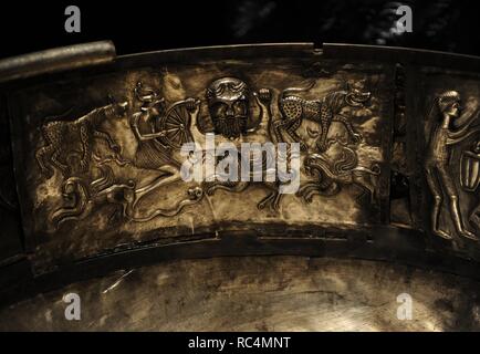 The Gundestrup cauldron. Decorated silver vessel, thought to date between 200 BC and 300 AD, placing it within the late La Te ne period or early Roman Iron Age. Gundestrup in the Aars parish of Himmerland, Denmark.  Scene showing the bust of a bearded god who holds a broken wheel in his righ hand, sometimes identified with the Celtic thunder god Taranos. The wheel is supported by a smaller figure with a horned helmet depicted in a jumping stance. Below the group is a single ram-horned serpent, three griffins and a pair leopards. National Museum of Denmark. Stock Photo