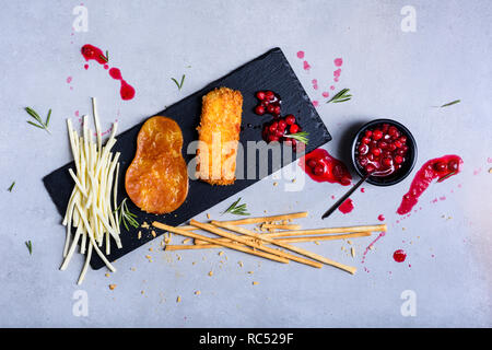 Cheese plates served with bread sticks and jam on a slate board. Top view. Stock Photo