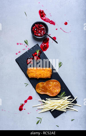 Cheese plates served with bread sticks and jam on a slate board. Top view. Stock Photo