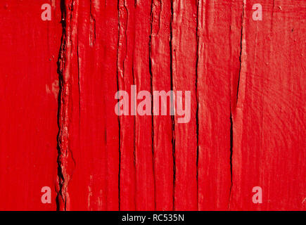 Rough, weathered wood is painted red with cracked, peeling paint, Dec. 23, 2018, in Mobile, Alabama. Stock Photo