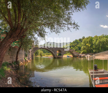 Skadar lake, Montenegro - 07.15.2018.  Panoramic view of the Old Bridge over Crnojevica river, Rijeka Crnojevica, and the tourist area near the bridge Stock Photo