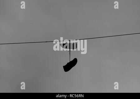 Sneakers hanging on wire Stock Photo