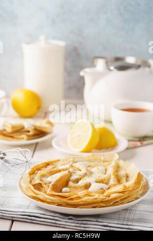 Lemon and sugar crepes or blini for dessert. Homemade pastry concept. Stock Photo