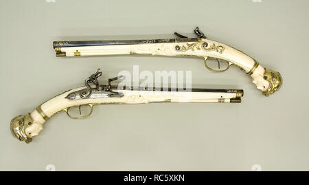 Pair of Flintlock Pistols. Culture: Southern Netherlandish, Aachen. Dimensions: L. of each 19 3/8 in. (49.2 cm); L. of each barrel 12 3/16 in. (30.9 cm); Cal. of each barrel .52 in. (13.2 mm); Wt. of each 2 lb. 3 oz. (992 g). Gunsmith: Leonardus Graeff (Aachen (now Germany), active ca. 1670-80). Date: ca. 1675-85.  Although Dutch in overall style, these pistols are unusual because they were made in Aachen rather than Maastricht and because the helmets on the pistol butts are separately made in gilt silver rather than carved in ivory. Museum: Metropolitan Museum of Art, New York, USA. Stock Photo