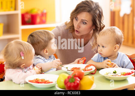 Cute little children eating healthy food at daycare centre Stock Photo