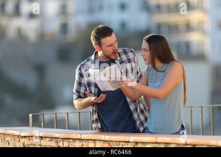 Angry couple arguing about travel destination on vacation in a town Stock Photo