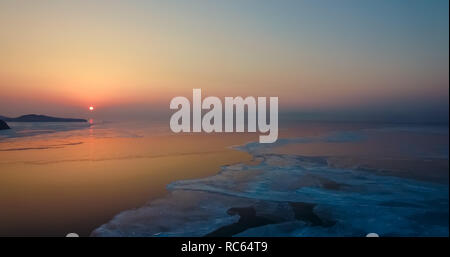 Aerial view of the sea landscape with sunset and ice floes on the sea Stock Photo