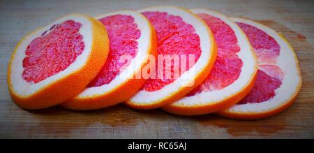 Sliced grapefruit on a wooden table Stock Photo