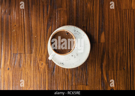Turkish or Greek Coffee on wooden table from top view. Traditional tasty refreshment hot coffee in coffee cup Stock Photo