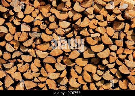 Background of dry, chopped and halved pine firewood logs in storage. Salo, Finland. Stock Photo