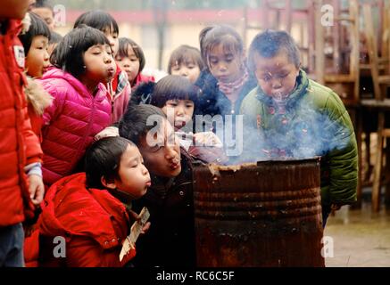 (190114) -- NANCHANG, Jan. 14, 2019 (Xinhua) -- Principal Zhang Zhanliang and students make fire to cook a meal at Huangni elementary school in Chuntao Town of Yujiang District of Yingtan City, east China's Jiangxi Province, Jan. 3, 2019. Zhang Zhanliang, the principal of Huangni primary school, has been known nationwide recently for taking care of the school's left-behind children, whose parents are migrant workers in towns and cities. For years, there's no canteen at Huangni elementary school. Appointed as principal in 2018, Zhang Zhanliang spent his own money cooking additional meal for the Stock Photo