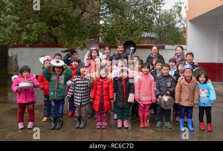 (190114) -- NANCHANG, Jan. 14, 2019 (Xinhua) -- Principal Zhang Zhanliang poses with all teachers and students for photos at Huangni elementary school in Chuntao Town of Yujiang District of Yingtan City, east China's Jiangxi Province, Jan. 4, 2019. Zhang Zhanliang, the principal of Huangni primary school, has been known nationwide recently for taking care of the school's left-behind children, whose parents are migrant workers in towns and cities. For years, there's no canteen at Huangni elementary school. Appointed as principal in 2018, Zhang Zhanliang spent his own money cooking additional me Stock Photo