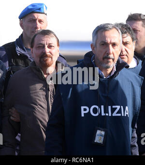 Rome, Italy. 14th Jan, 2019. Former left-wing militant Cesare Battisti (L) is escorted by police at the Ciampino Airport in Rome, Italy, Jan. 14, 2019. Cesare Battisti was extradited to Italy on Monday from Bolivia, where he was captured over the weekend by Italian, Brazilian and Bolivian agents after 38 years on the run. Credit: Alberto Lingria/Xinhua/Alamy Live News Stock Photo